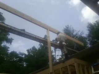 Carpenter setting a ridge beam over a new addition frame — Ice Dam Removal by Roofing Brothers in Cape Girardeau