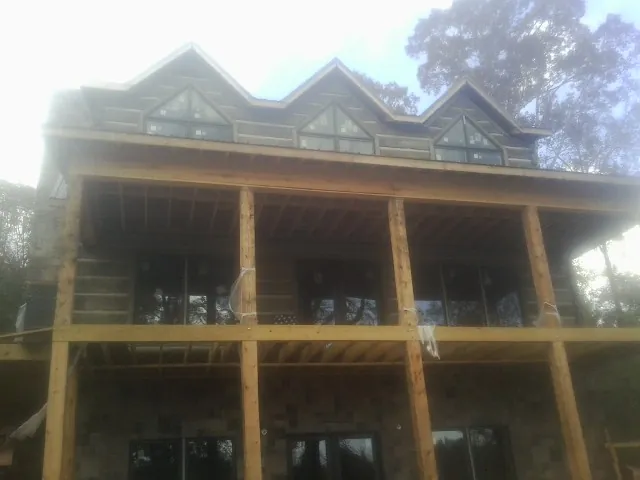 Dormers and porch framing on a large log home under construction — Roof Coating work by our crew in Cape Girardeau